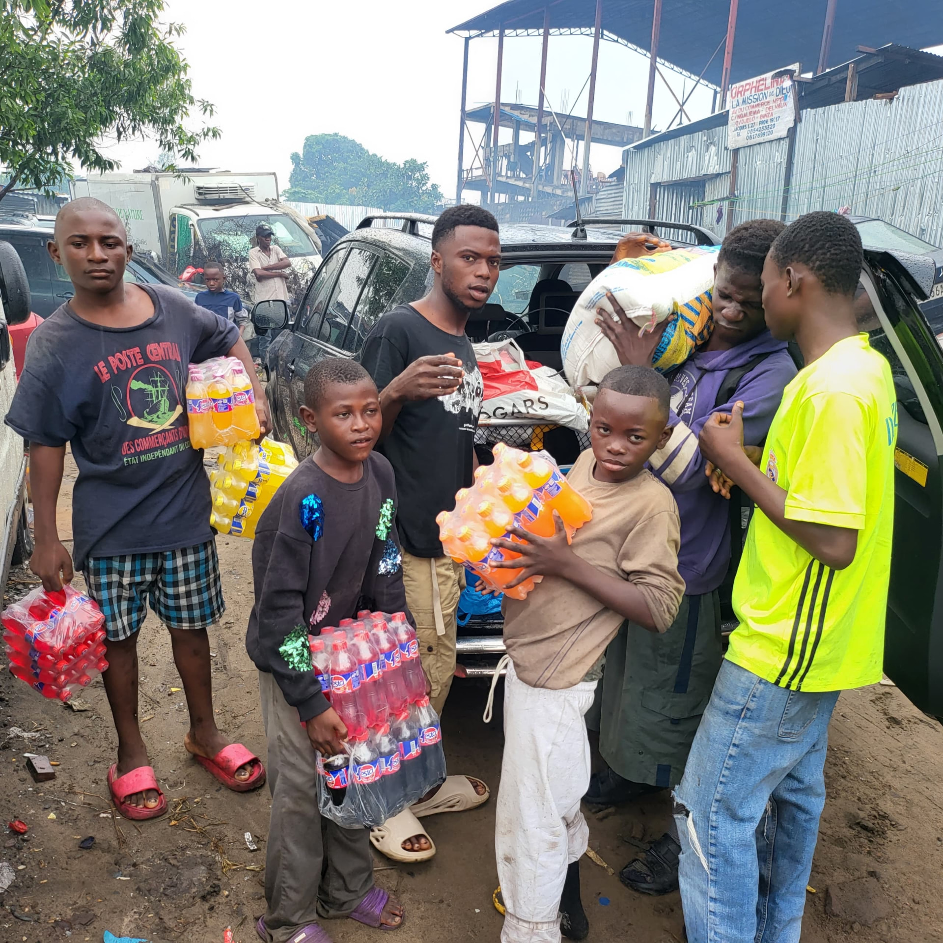 Enfants portant des packs de boissons offerts par la fondation