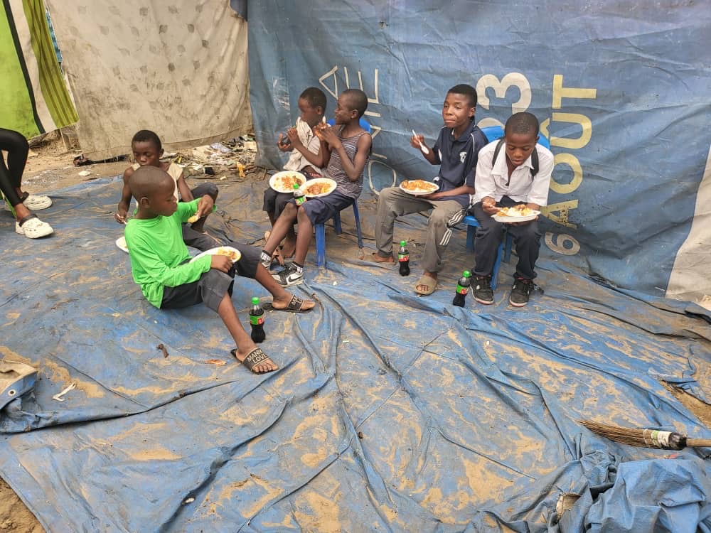 Enfants mangeant ensemble à l'ombre d'une bâche